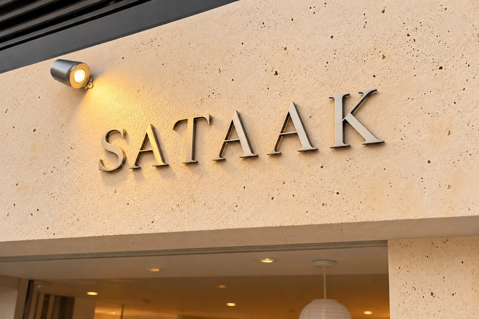 SATAAK metal letters on a stone wall