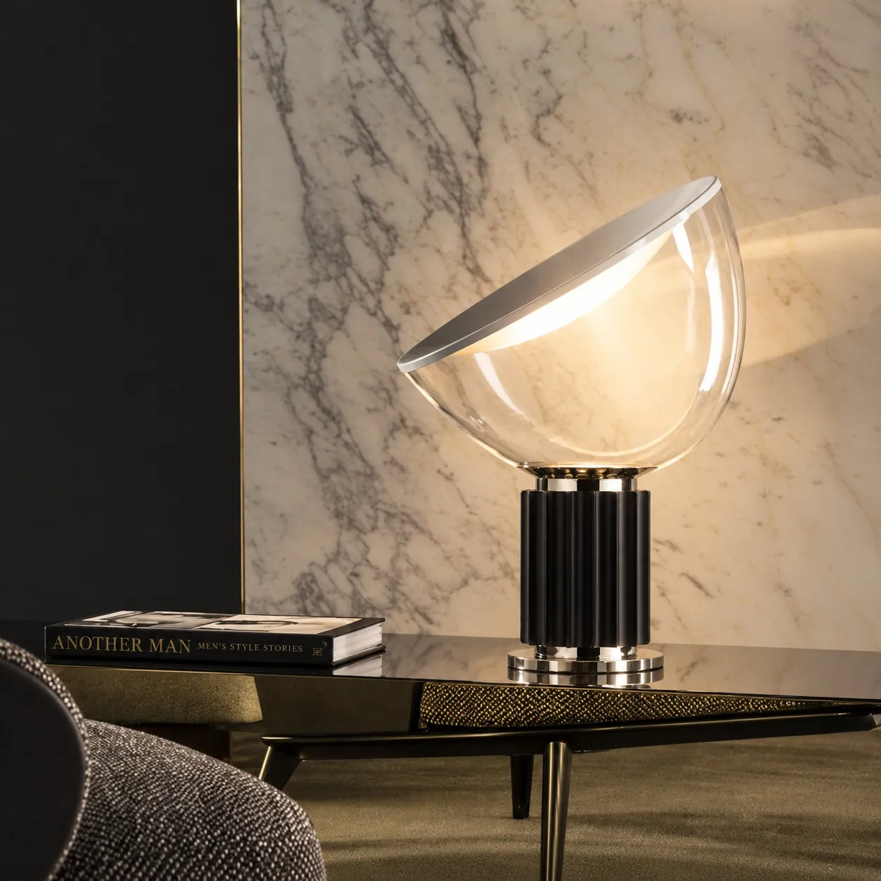Black glass bowl lamp on a table against marble