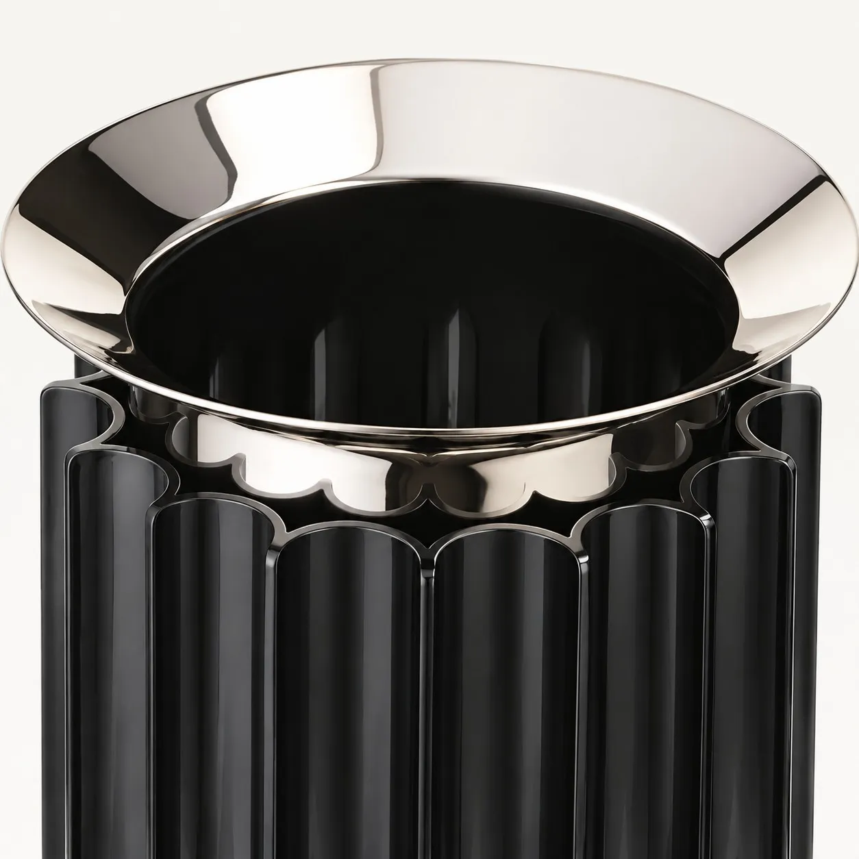 Polished metal dish set into a black ribbed base
