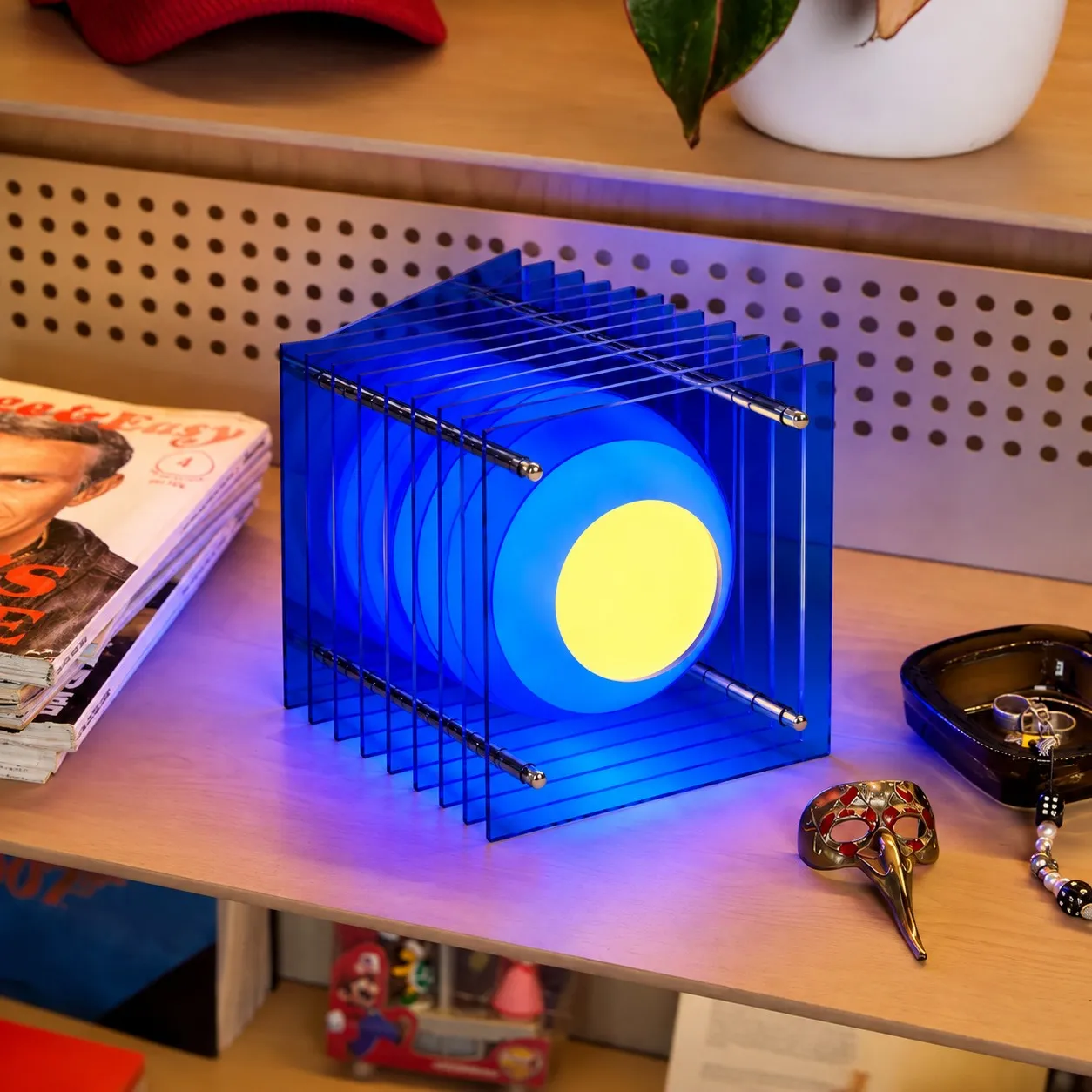 Blue acrylic cube lamp on a wood shelf