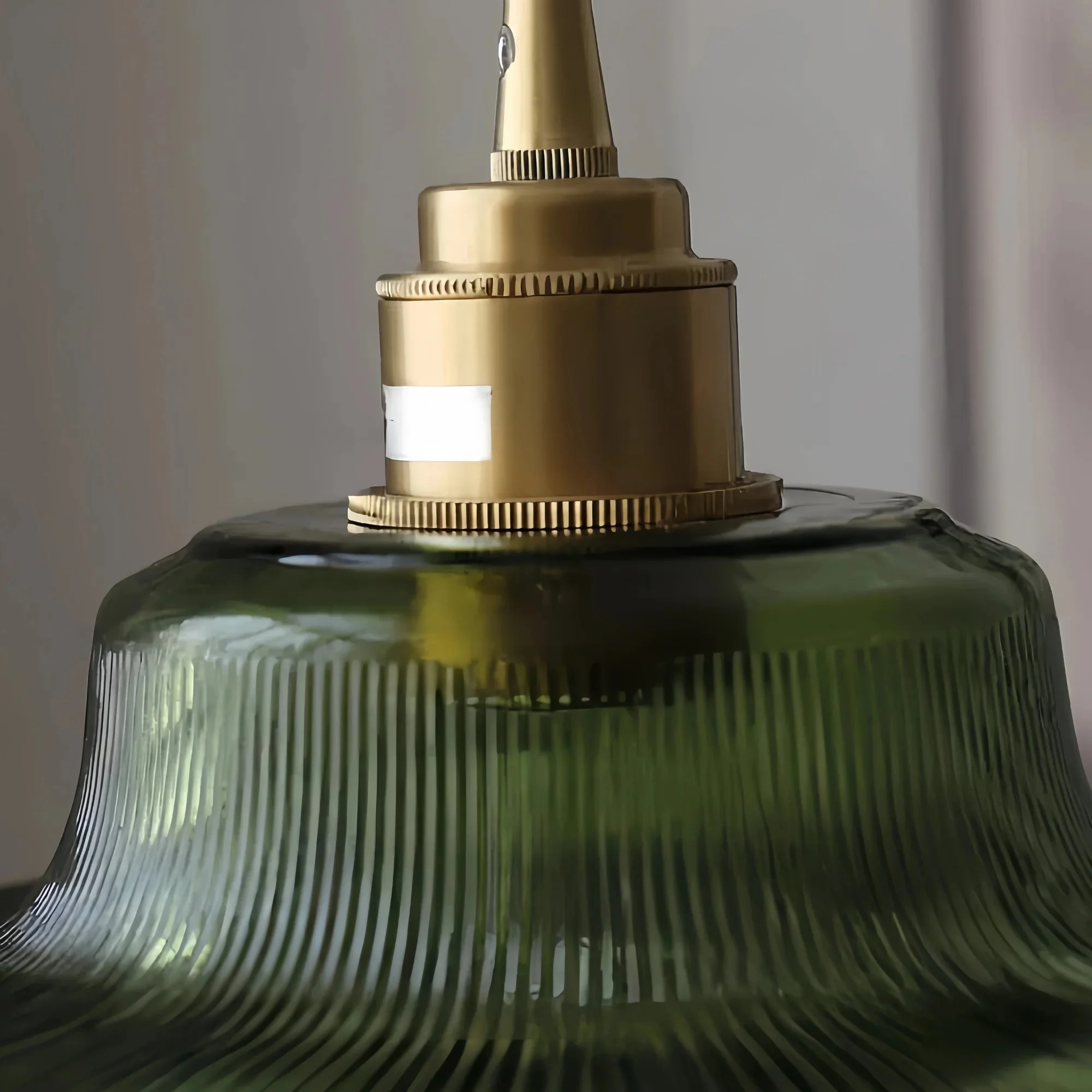 Brushed brass socket collar on green glass