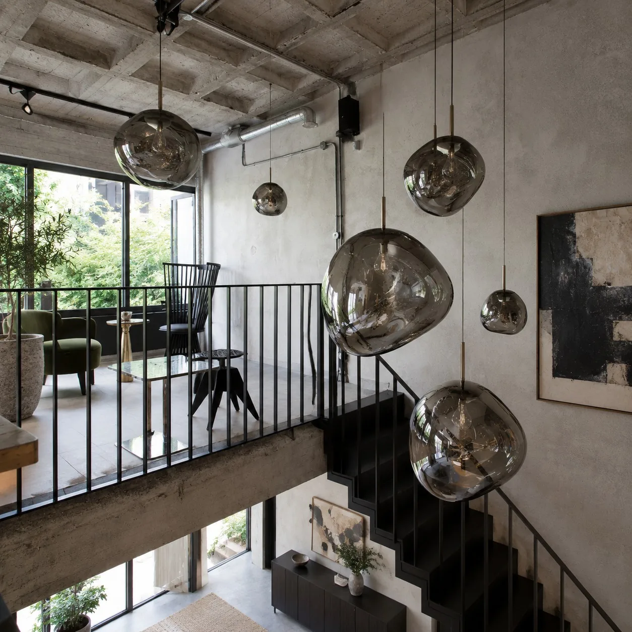 Smoked pendant cluster over an industrial stair