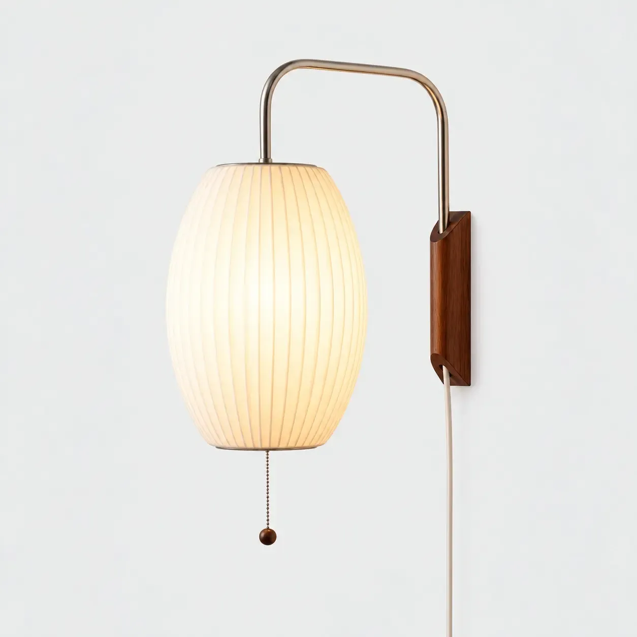 Oval ribbed wall sconce on a light background, shade lit