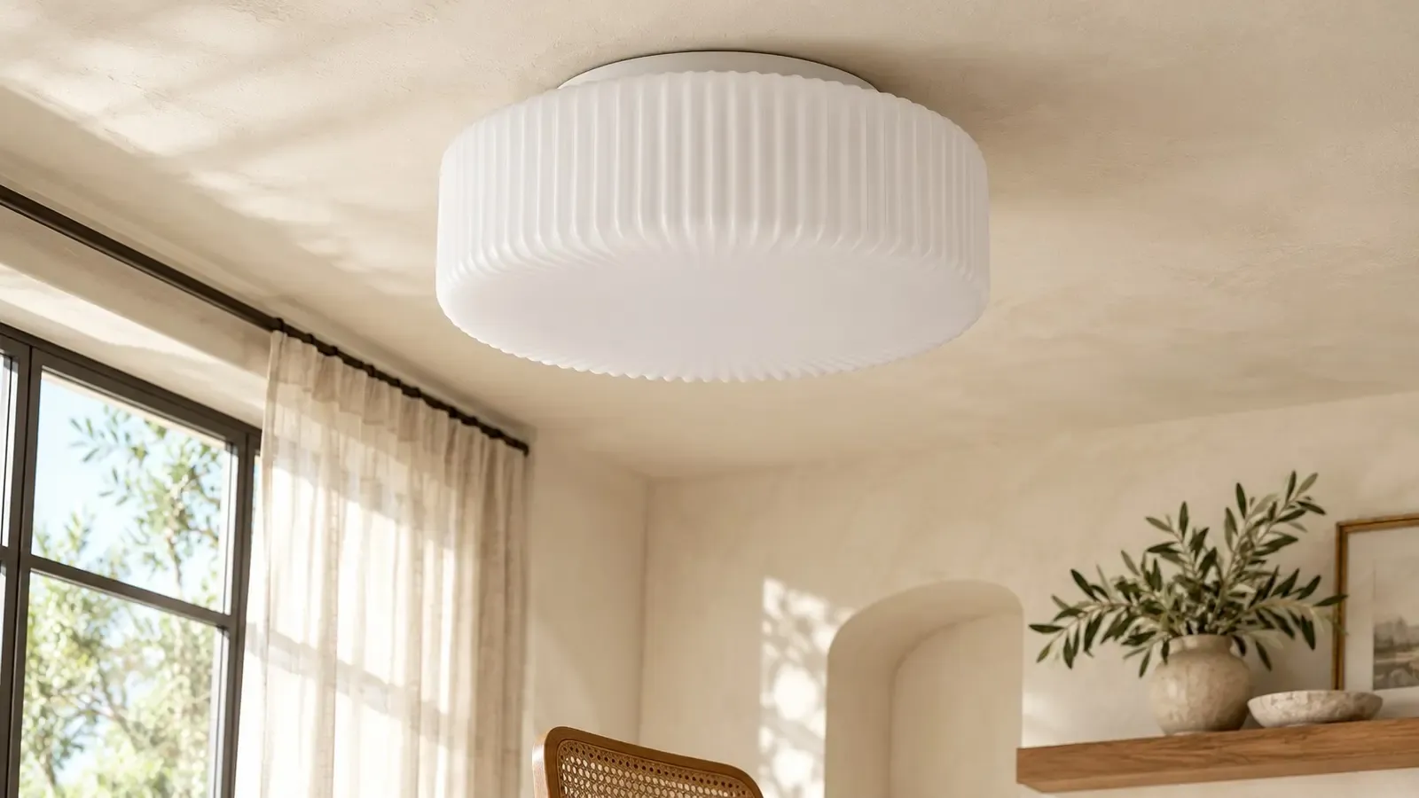 Opaline ribbed flush-mount ceiling lamp unlit on a plaster ceiling beside a window in daylight