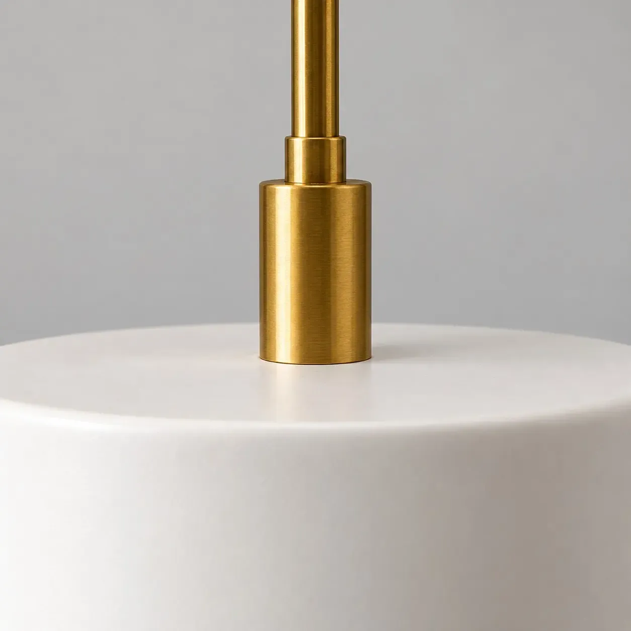 Close view of the metal collar where the rod meets the white porcelain shade