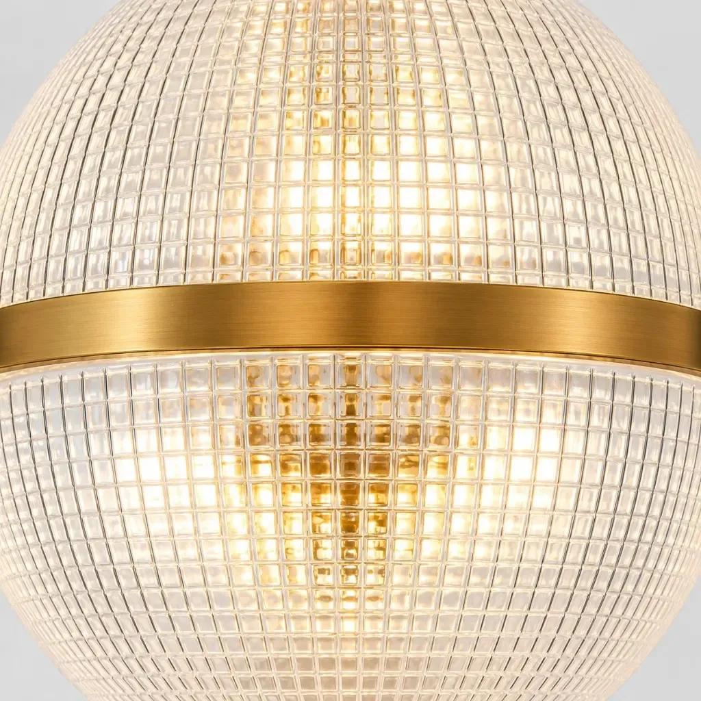 Hammered clear glass globe crossed by a brushed gold band, lit from inside