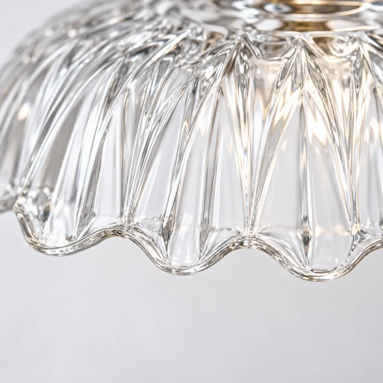 Close view of fluted clear glass ending in a scalloped rim