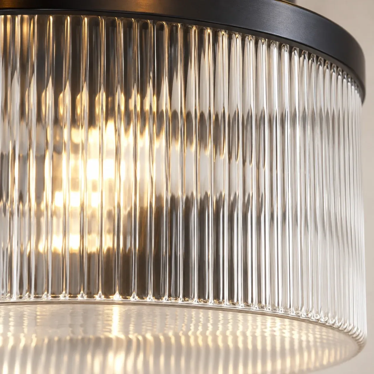 Vertical ribs in clear glass under a black metal ring