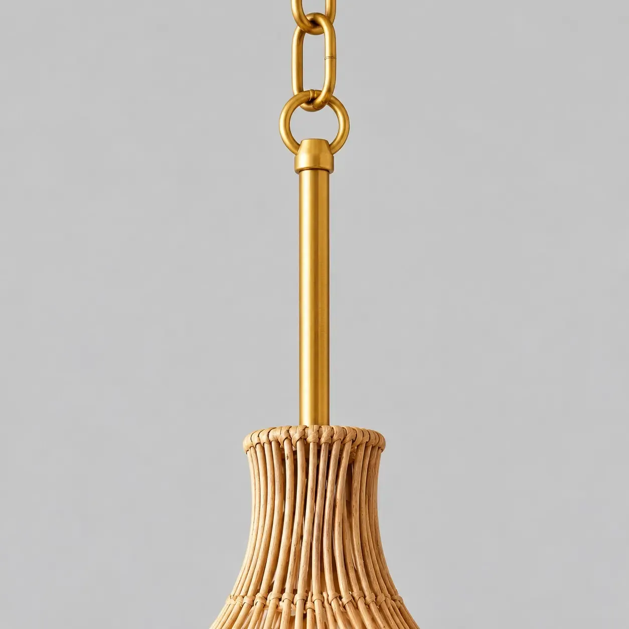 Warm gold-tone chain, loop, and rod above the rattan neck
