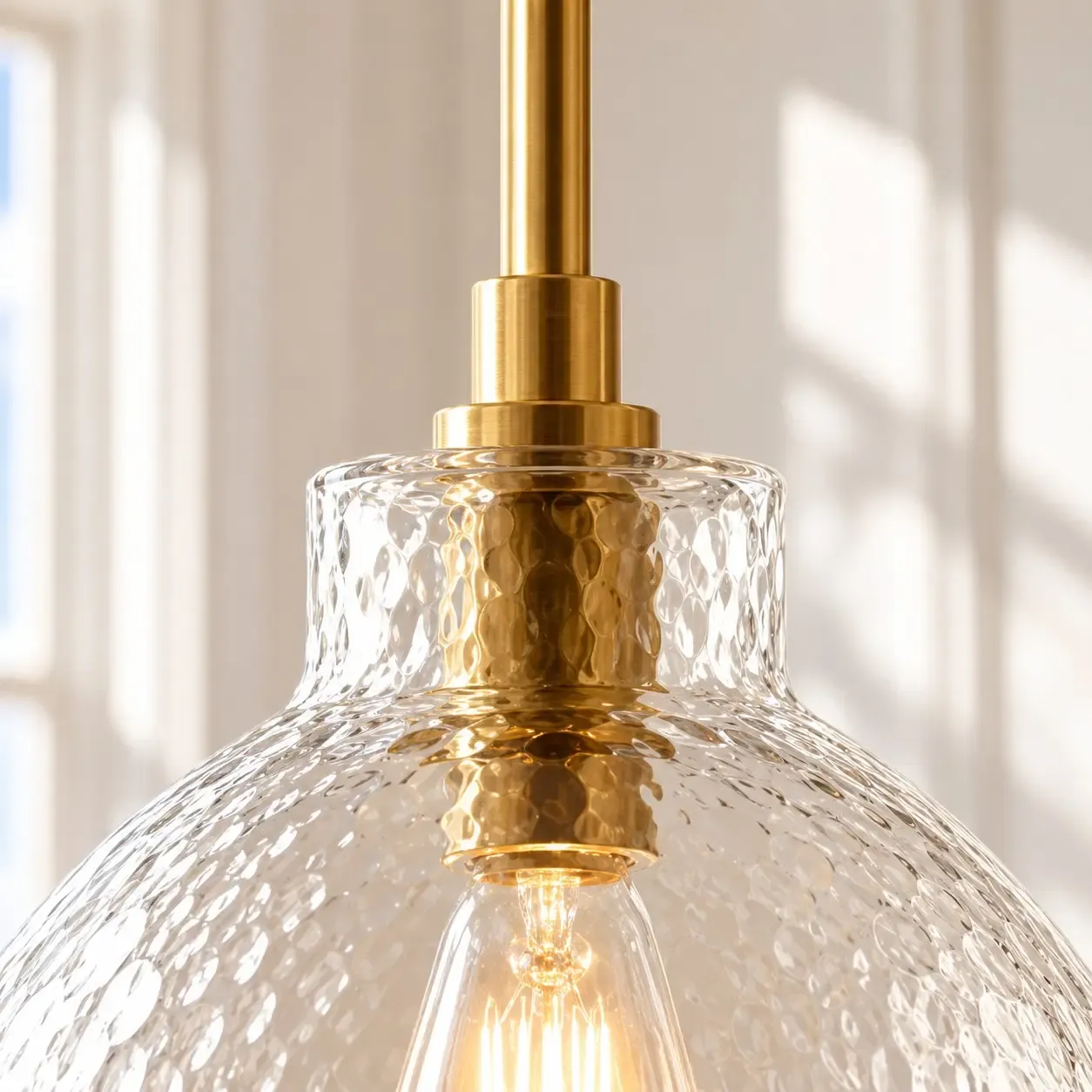 Brass rod and collar meeting hammered glass at the neck of the pendant