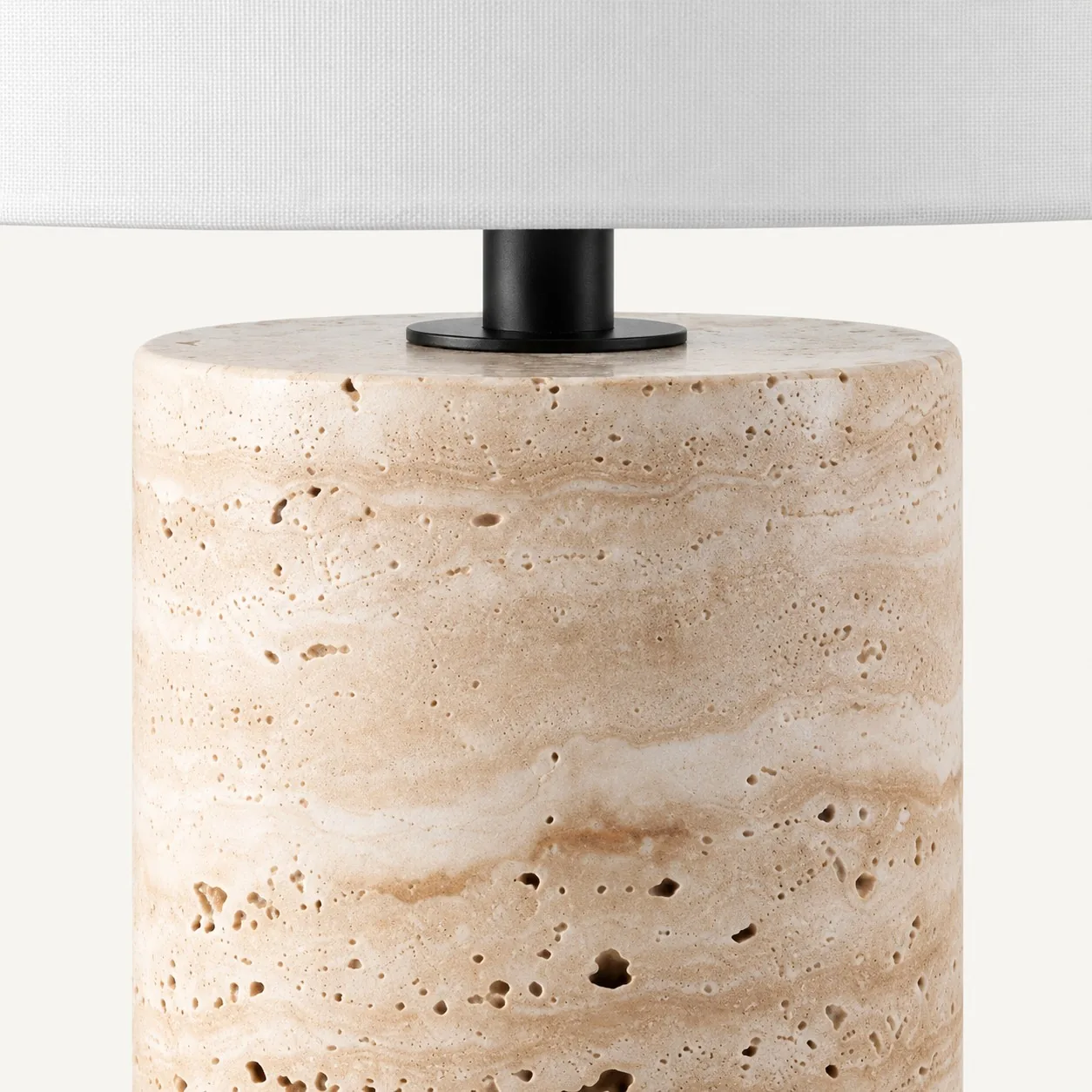 Matte black neck joining the travertine base and drum shade