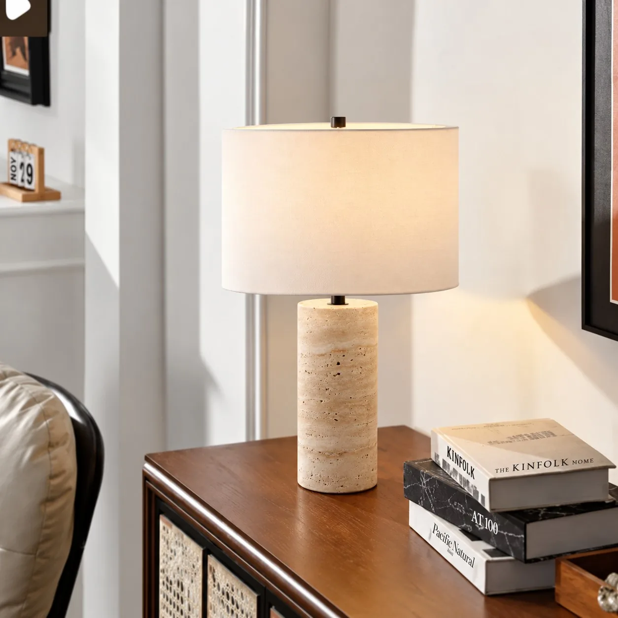 Drum Black travertine table lamp on a wood console