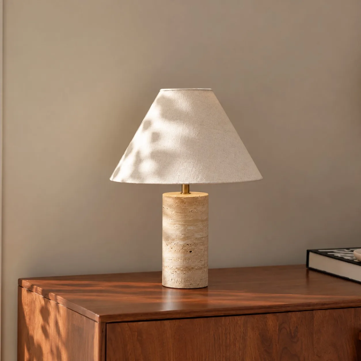 Cone Brass travertine table lamp on a wood cabinet