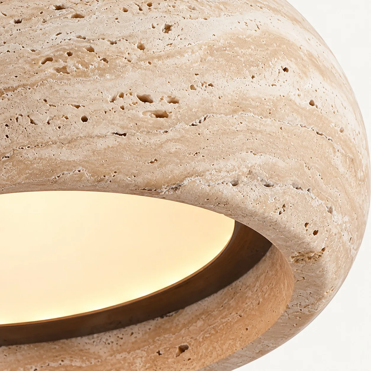 Warm glow through the recessed diffuser of the travertine drum